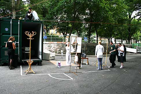 Image: Home installation in public space with film projection, furniture, other elements and performance